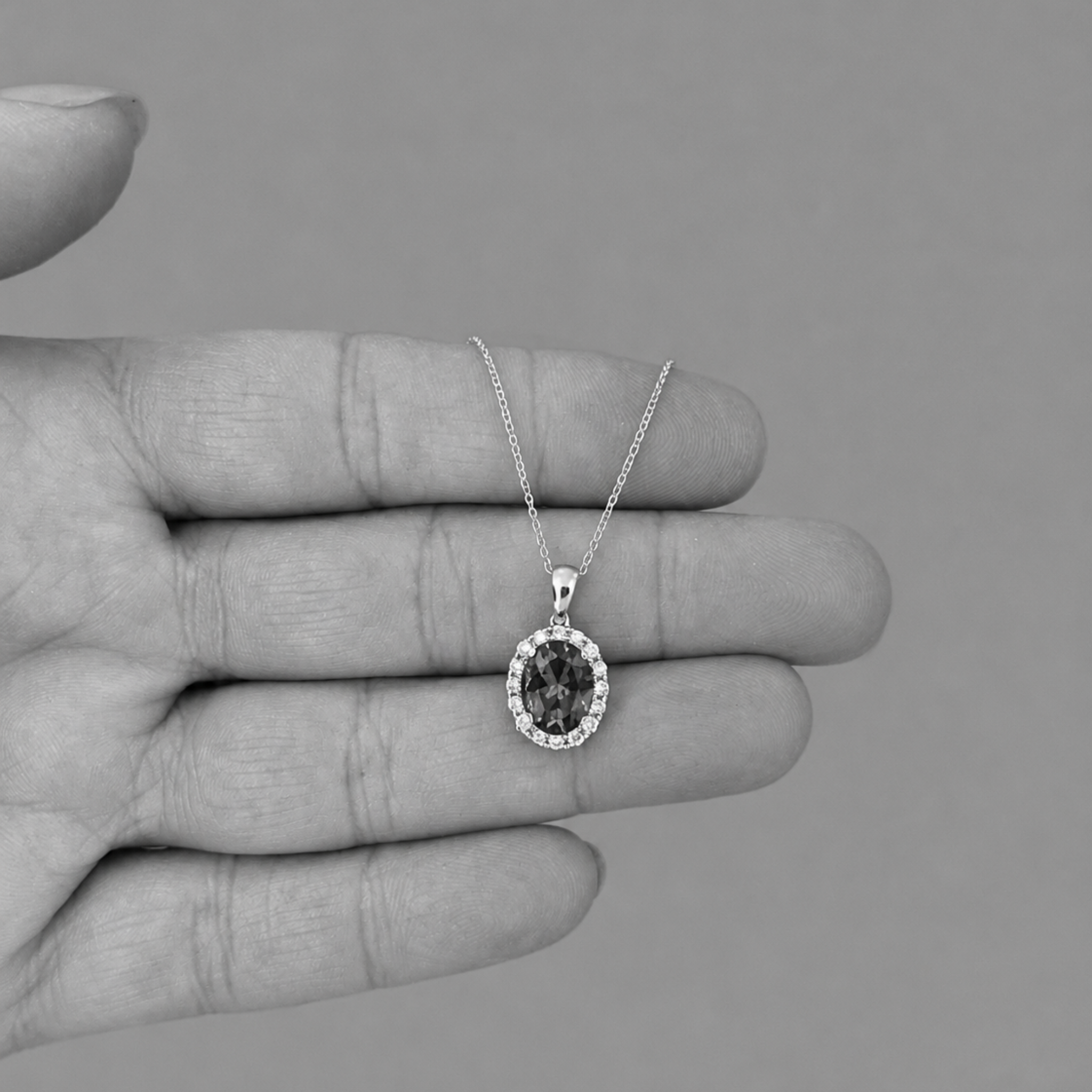 A  oval tanzanite pendant necklace with a halo of diamonds stones,