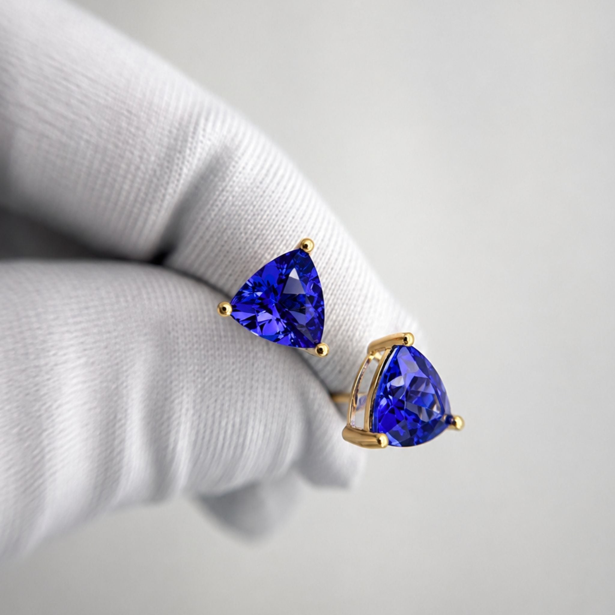 Top-grade Tanzanite Trillion Cut Earrings in 14K White Gold featuring vivid blue-violet tanzanites and diamond accents